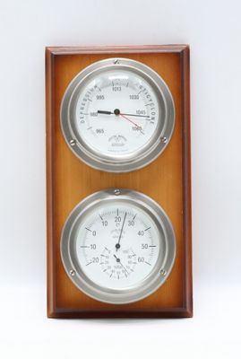 deux horloges fixées sur un mur en bois, sur fond blanc