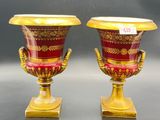pair of red and gold vases sitting on top of a table