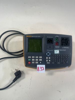 un gros plan d'une calculatrice posée sur une table à côté d'un chargeur