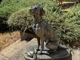a statue of a dog that is sitting on a plate