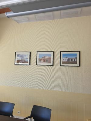 trois tableaux encadrés accrochés au mur d'une salle de réunion