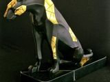 statue of an egyptian cat on a black base against a black background