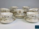 six tasses et soucoupes posées sur une table blanche
