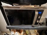 un micro-ondes posé sur une étagère
