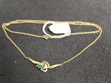 a close up of a gold chain with a green stone on it
