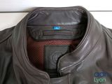 the back of a brown leather jacket with a blue tag on it