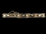une image montrant un gros plan d'un bracelet en or sur fond noir
