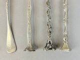 four spoons and a fork on a table