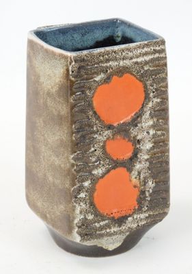 a small vase with two orange hearts on it