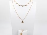 un mannequin blanc portant un collier, un bracelet et une bague en or