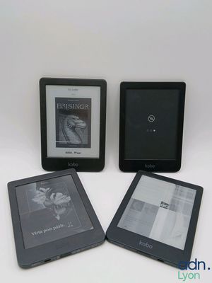 Trois livres Kindle sont posés les uns à côté des autres sur une table