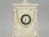 une horloge en marbre blanc surmontée d'une coupe
