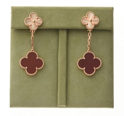 une photo d'une paire de boucles d'oreilles posée sur une boîte verte