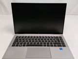 a silver laptop with a black keyboard on a white surface