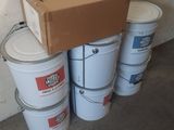 several buckets of white paint sitting next to a box on top of a cement floor