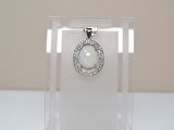 a glass display case with a white stone pendant on it