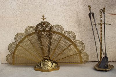 un éventail en or posé sur une table, à côté d'autres objets
