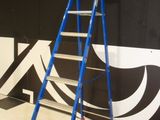 a ladder that is sitting on the floor in front of a wall