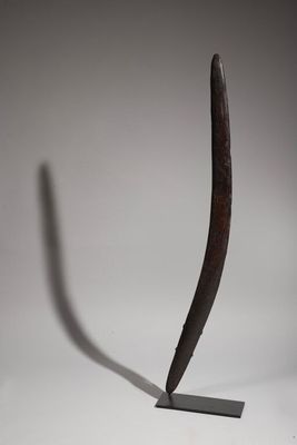 sculpture of a curved piece of metal on a stand with a shadow