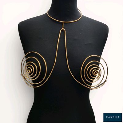 un torse de mannequin noir orné de spirales dorées