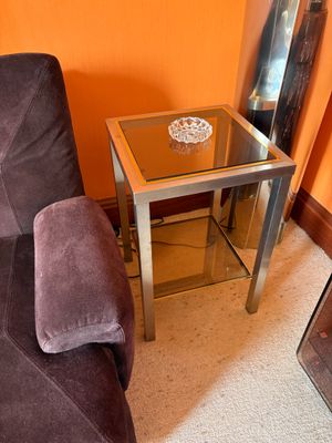 a glass table with a bowl on it in the corner of a living room