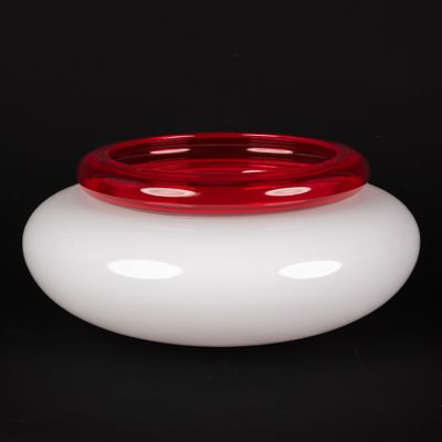 un vase blanc avec un couvercle rouge sur fond noir