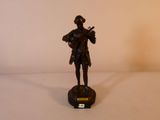 une statue en bronze représentant un homme jouant du violon