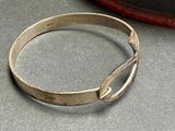 a silver bracelet that has a curved design on it