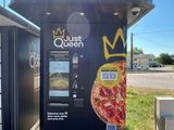 un distributeur automatique sur lequel est posée une pizza
