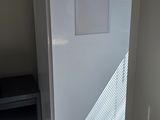 a white refrigerator in the corner of a room next to a tv