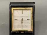 une image représentant une horloge noire et dorée posée sur une table