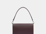 the small leather shoulder bag is made from dark brown leather