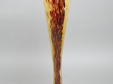 a close up of a glass vase on a stand on a white surface