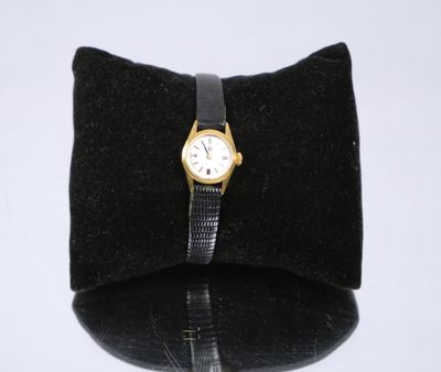 un petit sac noir orné d'une montre en or