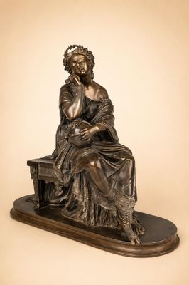une statue en bronze représentant une femme assise sur un banc