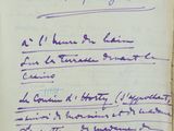 un vieux livre sur lequel est inscrit un poème écrit à la main, posé sur une table
