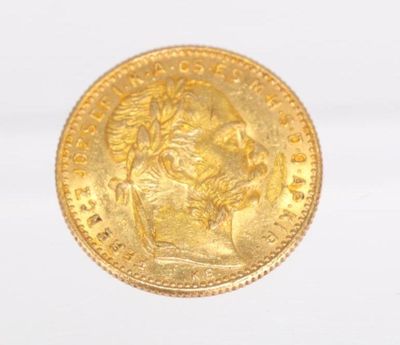 a close up of a gold coin on a white surface