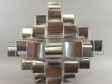 a silver sculpture made out of metal squares on a table