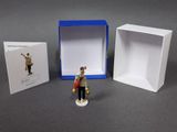 a small figurine of a man standing in front of a box
