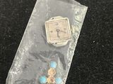 a small watch and a pair of earrings in a plastic bag