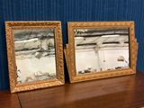 deux miroirs posés sur une table, avec un rideau bleu en arrière-plan