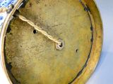 a gold clock with a blue and white design on it