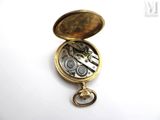 a gold pocket watch with a chain hanging from it ' s side