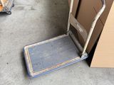 a hand truck that is sitting on the floor next to a cart