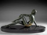 bronze sculpture of a woman sitting on a black base