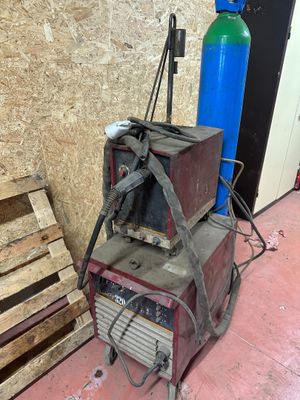 une photo montrant une machine à souder posée à côté d'une pile de palettes
