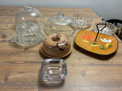 a wooden table topped with glass dishes and dishes