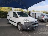 a white van parked in a parking lot under a blue umbrella