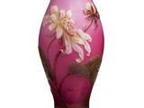 un vase rose sur lequel sont peintes des fleurs, sur un fond blanc