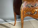 a small wooden table with a marble top on a tiled floor